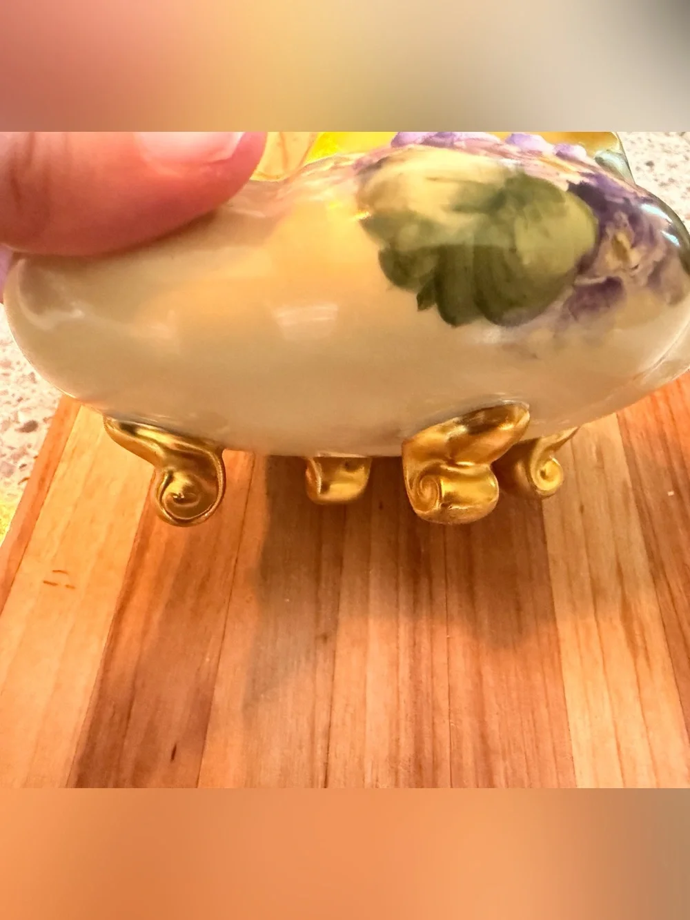 A hand-painted porcelain footed bowl with gilded rim and floral decoration.